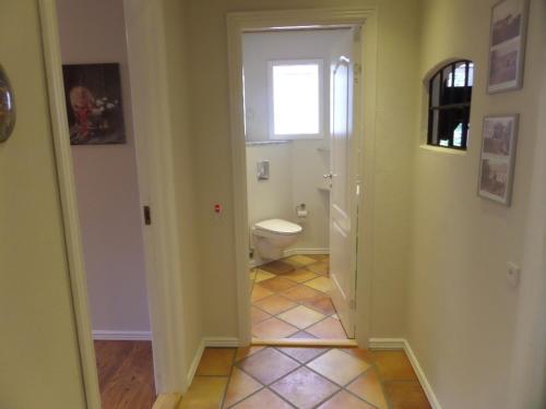 a bathroom with a toilet and a window at Rosengaard holiday apartment and B&B in Bramming