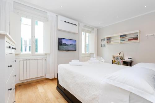 a white bedroom with a large bed and windows at Comfortable and Convenient apt in the center - Zanobi Delux in Florence