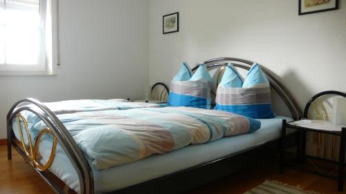 a bed with blue and white pillows on it at Ferienwohnung Gisela in Bausendorf