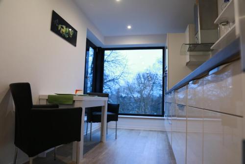 a kitchen with a table and chairs and a large window at Wohnkomfort wie Zuhause in Neubrandenburg