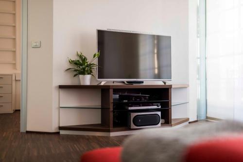 a living room with a flat screen tv on a entertainment center at Life Apartment & City Bike in Bolzano