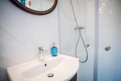 a bathroom with a sink and a shower with a mirror at Pause Apartment with Free Parking in Budapest
