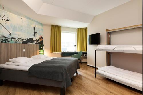 a hotel room with two beds and a desk at Good Morning+ Halmstad in Halmstad
