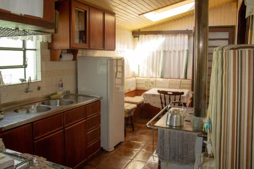 eine Küche mit Spüle und Kühlschrank in der Unterkunft Nossa casa em Canela in Canela