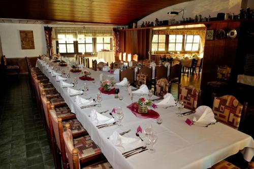 a long long table in a room with white table cloth at Zum Mühlehannes in Rohrbach