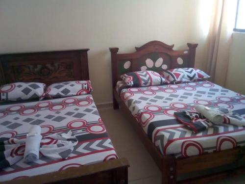 dos camas sentadas una al lado de la otra en un dormitorio en Hotel Táchiras, en Bucaramanga