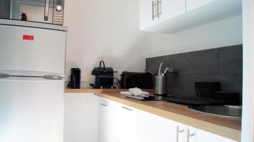 une cuisine avec un évier et un plan de travail dans l'établissement Appart Hôtel Lille Baudoin, à Lille