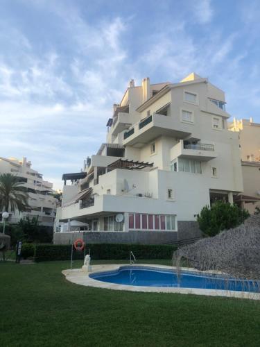 Un edificio con piscina enfrente. en Real Torrequebrada, en Benalmádena