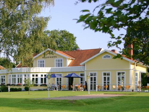 a large white building with tables and chairs at Hestraviken Hotell & Spa in Hestra