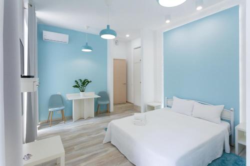 a bedroom with a white bed and a blue wall at Basseynaya Apart Hotel in Kyiv