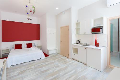 a bedroom with a white bed and a red wall at Basseynaya Apart Hotel in Kyiv