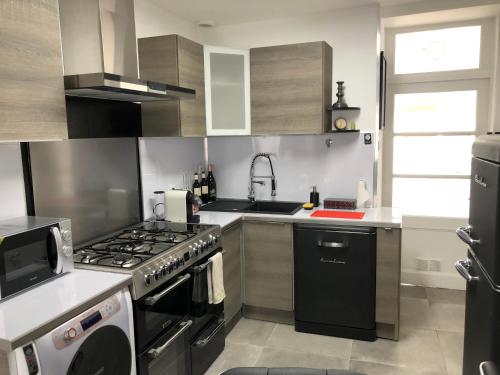 une cuisine avec une cuisinière et un évier dans l'établissement La Suite Nolyvan, à Saint-Malo