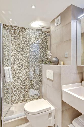 une salle de bain avec toilettes, lavabo et douche dans l'établissement Luxury Apartment Paris Louvre, à Paris