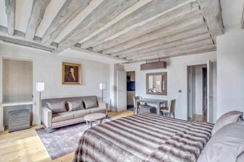 - une chambre avec un lit et un canapé dans l'établissement Luxury Apartment Paris Louvre, à Paris
