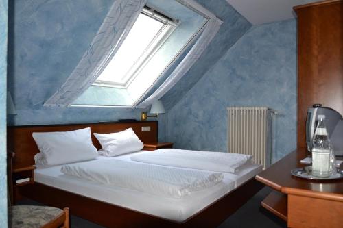 a bedroom with a bed with a window above it at Altes Rathaus am Elz Garten in Rust