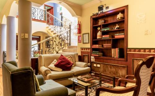 a living room with two couches and a book shelf at Casa Aliso Hotel Boutique in Quito