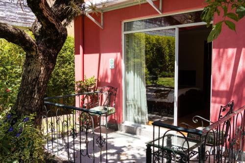 a red house with two chairs and a tree at Casa Aliso Hotel Boutique in Quito