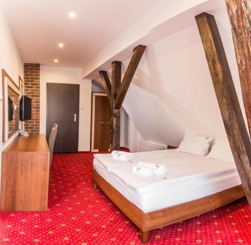 a bedroom with a bed and a red carpet at Fregata in Ełk