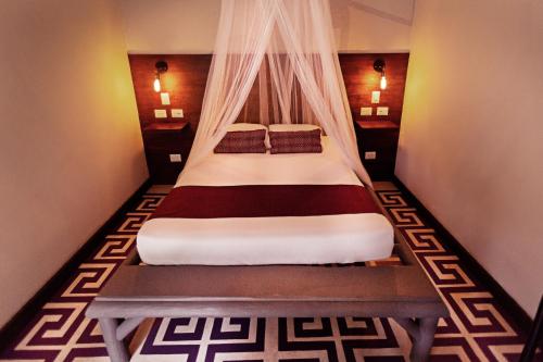 a bed with a canopy in a room at Jungle Lodge Tikal Hostal in Tikal