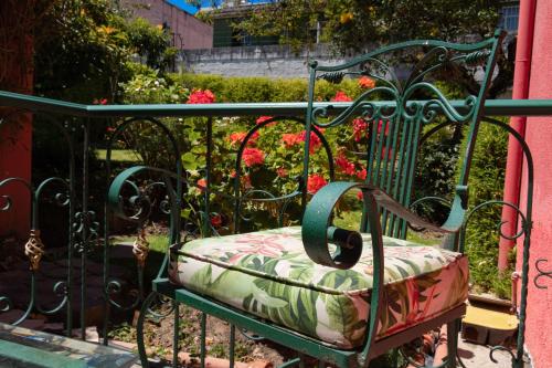 a green bench with a cushion on it next to a garden at Casa Aliso Hotel Boutique in Quito