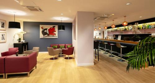 a bar in a restaurant with red chairs and a counter at Best Western Plus Hotel & SPA Le Schoenenbourg in Riquewihr