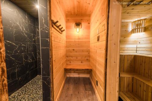a sauna in a log cabin with wooden walls at Chalet TAO par Les Chalets Spa Canada in La Malbaie