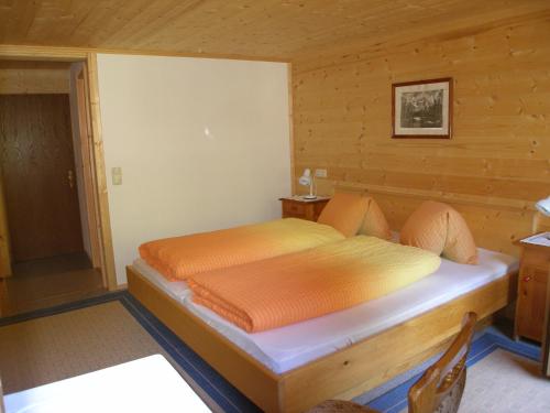 ein Schlafzimmer mit einem Bett in einem Holzzimmer in der Unterkunft Gästehaus Dorer Gerhard in Prägraten