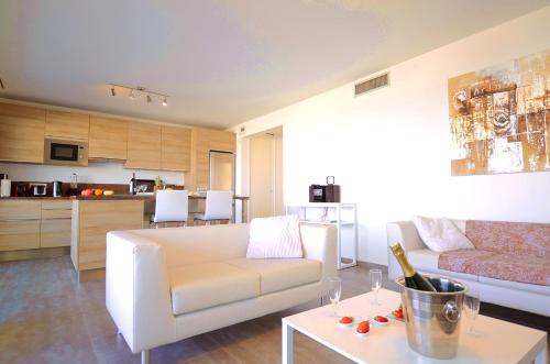 a living room with a white couch and a table at Résidence Dary in LʼÎle-Rousse