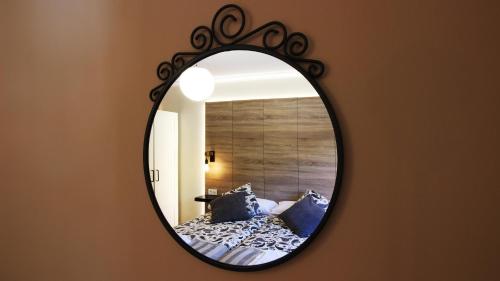 a mirror on a wall with a bed in a room at Casa Rural LA COVA in Suano
