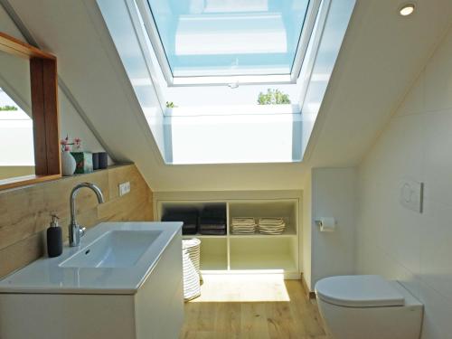 ein Badezimmer mit einem Waschbecken und einem Dachfenster in der Unterkunft Kling am See in Friedrichshafen