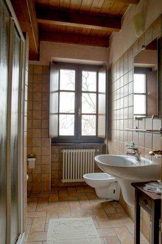 a bathroom with a sink and a toilet and a window at Corte Fattori in Monzambano