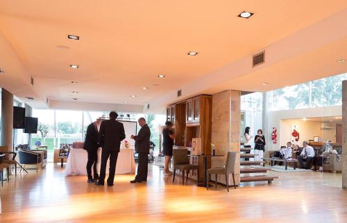 a group of three men standing in a lobby at Herradura Hotel Suites in Neuquén