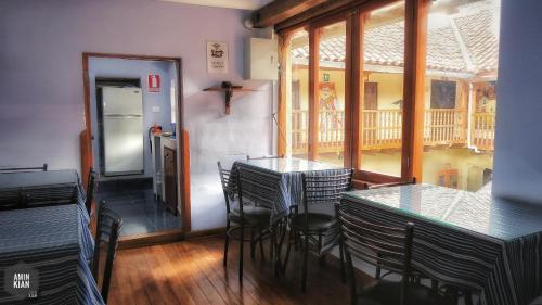 uma sala de jantar com mesas e cadeiras e um frigorífico em OkiDoki Cusco Hostal em Cusco