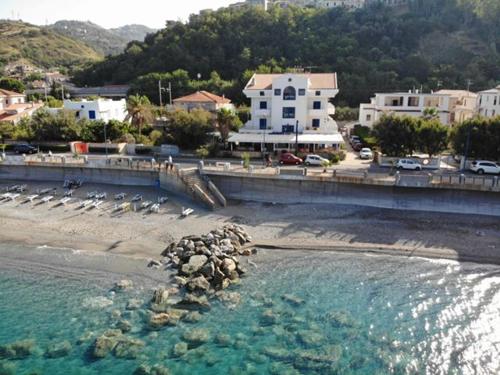 a body of water with a beach and buildings at Sea Garden Hotel in Acquappesa