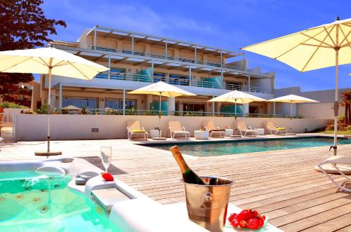 una botella de vino en una mesa junto a la piscina en Résidence Dary, en LʼÎle-Rousse