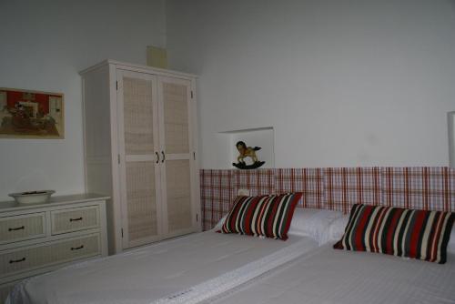 a bedroom with a bed with two pillows and a cabinet at Casa Cristeta in Medina de Pomar
