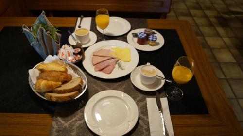a table with plates of food and glasses of orange juice at Hotel Restaurant Kreuz in Kaiserstuhl