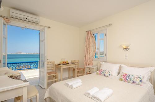 a bedroom with a bed and a view of the ocean at Orkos Blue Coast in Mikri Vigla
