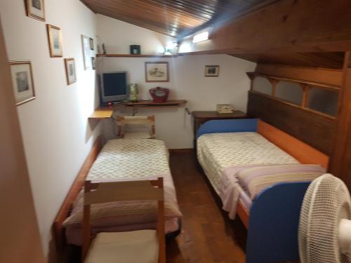 two beds in a small room with a tv at Agriturismo Collelungo di Maremma in Diaccialone