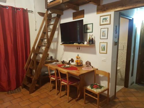 a dining room with a table and a television on a wall at Agriturismo Collelungo di Maremma in Diaccialone