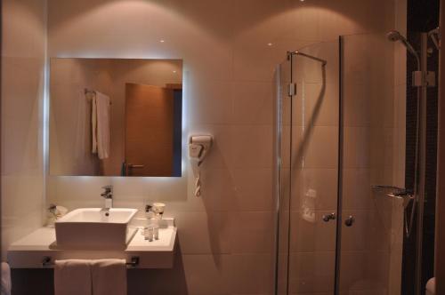 a bathroom with a sink and a shower with a mirror at Studio Elegance in Golden Sands