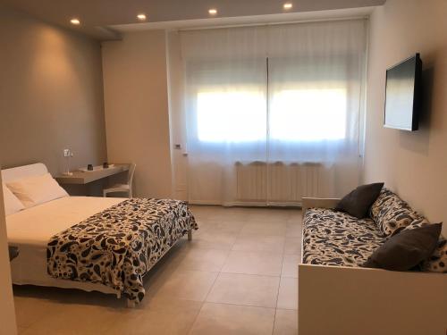 a bedroom with a bed and a couch and a window at Villa Sami in Vasto