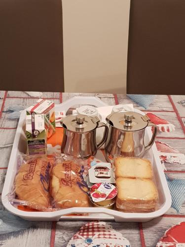 a tray with two tea pots and sandwiches on a table at le tre torri in Maranola