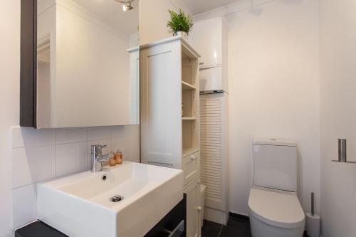 a bathroom with a white sink and a toilet at Charming Paddington in London