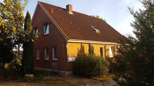 a brown and yellow house with a brown roof at Lily-Rose Cottage in Vastorf
