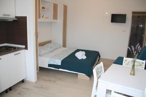 um pequeno quarto com uma cama, uma mesa e uma cozinha em Lavanda em Podstrana