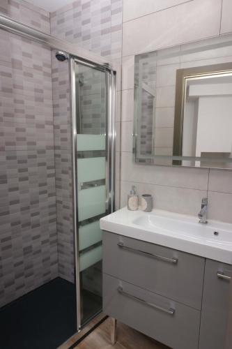 a bathroom with a sink and a shower with a mirror at A Casa das Burgas in Cuntis