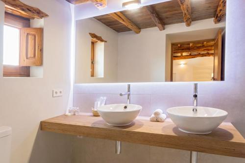 
a bathroom with two sinks and a large mirror at Agroturismo Can Toni Xumeu - Adults Only in Cala Llonga
