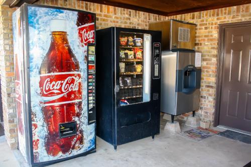 a coca cola machine with a bottle of soda at Rayburn Inn in Brookeland