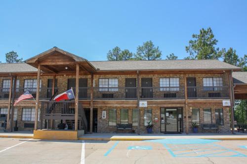a building with a flag in front of it at Rayburn Inn in Brookeland